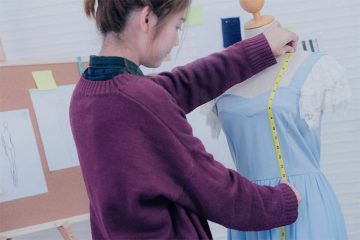 A woman is showing how to measure a skirt length
