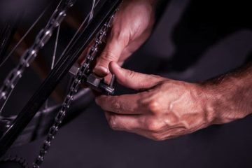 A close-up picture of a hands showing how to measure bike chain