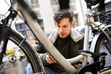 A man is showing how to measure bike frame outside