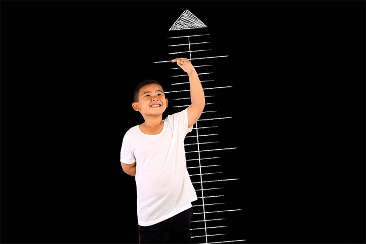 A boy on a black background with a height scale drawn