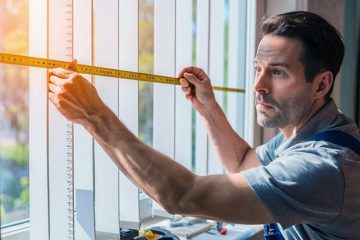 A man is showing how to measure vertical blinds