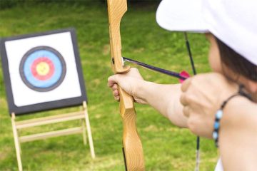A girl is showing how to measure draw length