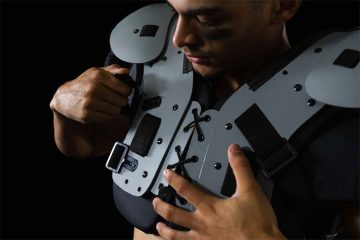 A man is showing how to measure for football pads