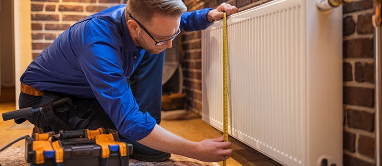 A man is showing how to measure radiator size