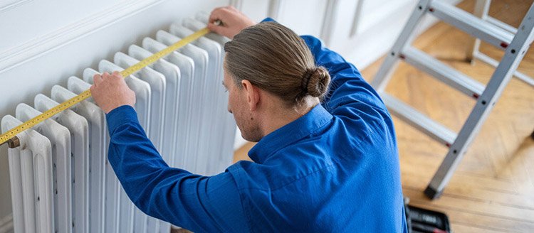 How to Measure Radiator Size Fast and Easy 2 A worker is measuring the top of the radiator size