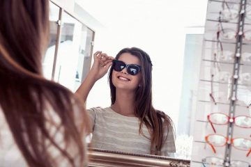 A girl in front of a mirror is showing how to measure for sunglasses